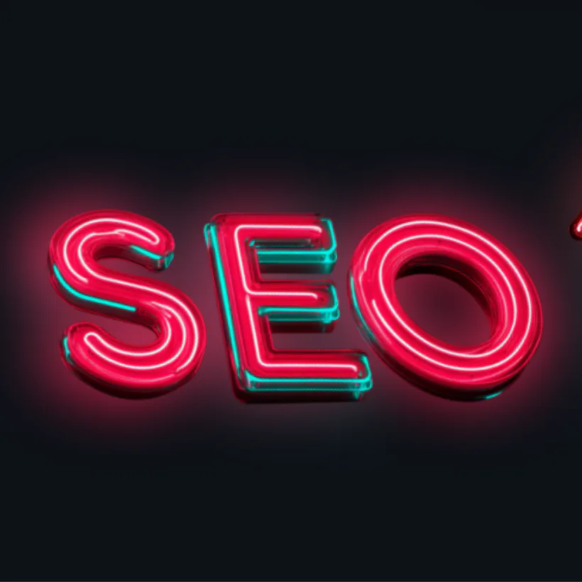 Glowing neon sign displaying 'SEO' in bright pink and cyan lights against a dark background, symbolizing search engine optimization and digital marketing technology
