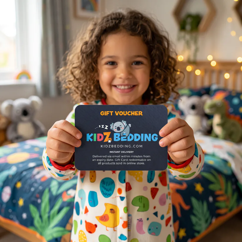 Smiling child with curly brown hair holding a dark blue Kidz Bedding gift voucher card in a colorful bedroom with patterned bedding and stuffed animals