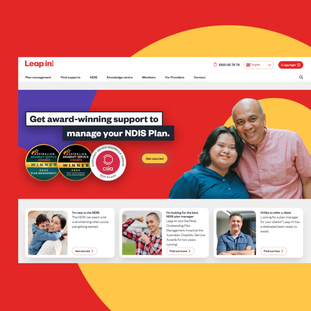 Smiling man in pink shirt and woman in blue shirt standing together against red background with yellow circular design. Features award-winning badges for Australian Disability Service and CSID cert...