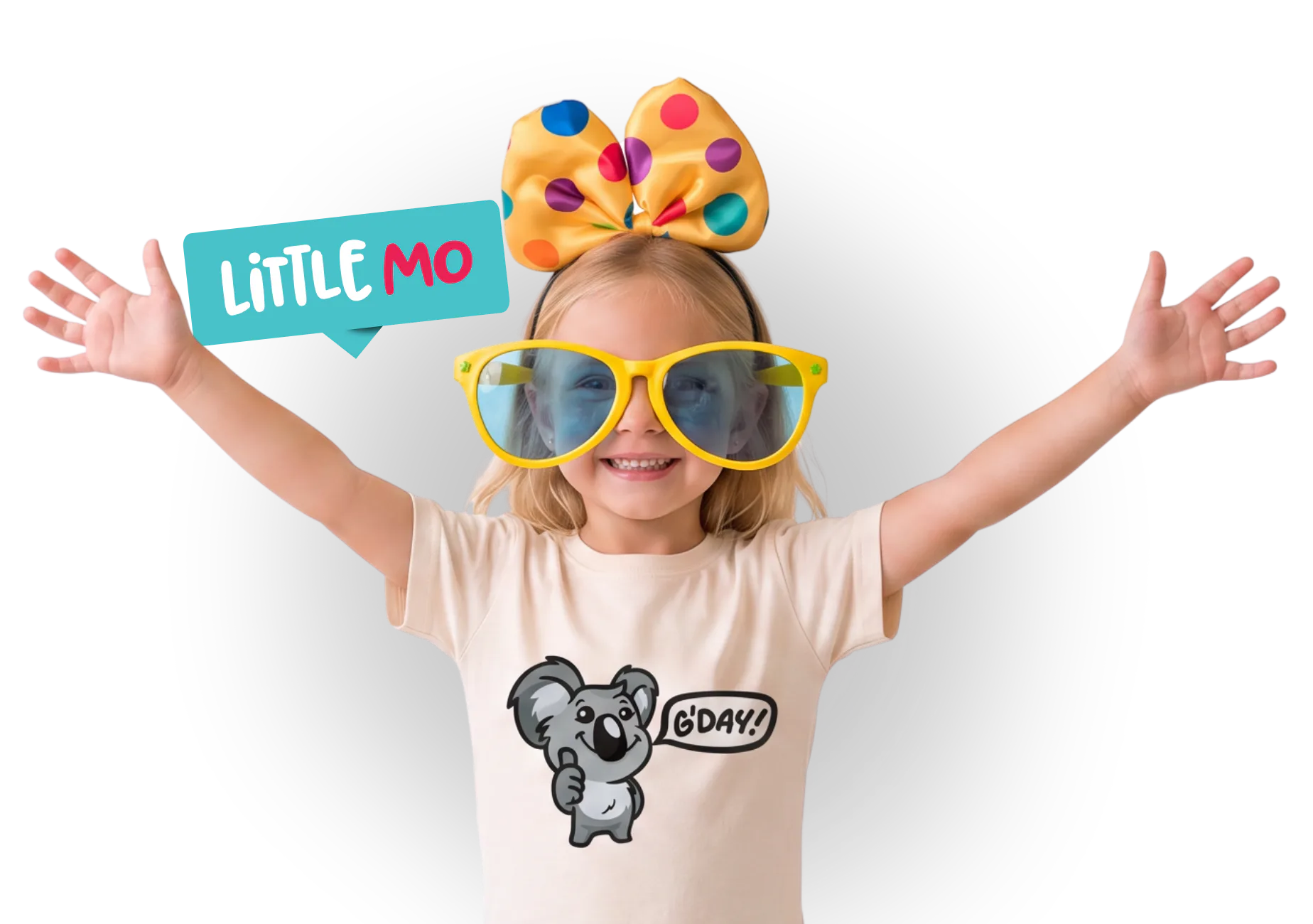 Young child wearing oversized yellow sunglasses and colorful paint palette bow, arms raised joyfully, wearing cream 'koala g'day' graphic tee with turquoise 'Little Mo' logo speech bubble
